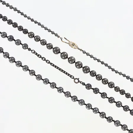 Två collier med kulor av hematit, 55 och 59cm långa, ett med silverlås och ett med stållås, 