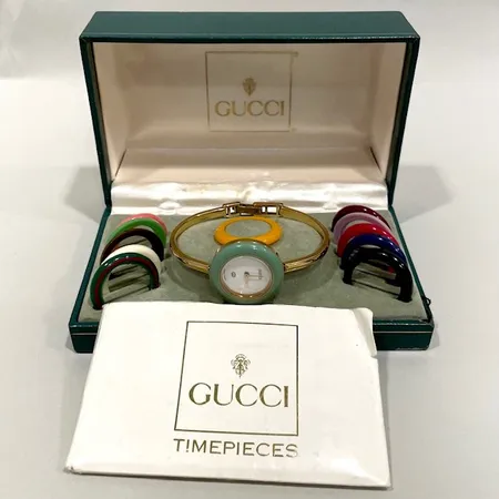 Damur Gucci, 12 utbytbara färgringar, Ø26mm, armband ca 17cm, ref-nr: 11/12, serie-nr: 0548063, quartz, gulmetall, behov av batteribyte, repig metall, manualer, sliten box.