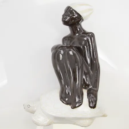 Skulptur Mari Simmulson "Kvinna på sköldpadda", höjd ca 25cm, glaserat stengods, stickhål samt tillverkningsdefekter.