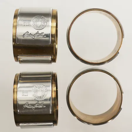 Fyra servettringar, formgivna av Sebastian Schildt för Firma Svenskt Tenn, 2016, tenn och mässing, ca Ø4cm, bredd ca 3cm, samtliga med tygpåse, repor, missfärgad mässing, behov av puts.