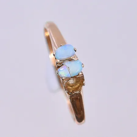 Ring med imitations opal, stl 16¾, bredd 1-5 mm, en trasig sten och en saknas, 18K. Vikt: 1,4 g