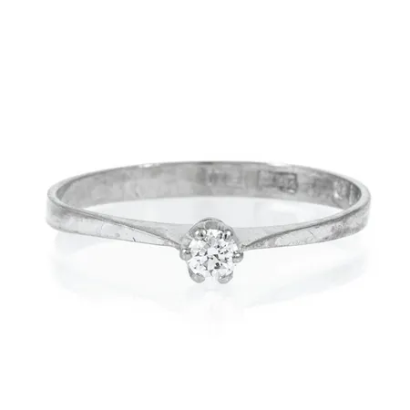 Ring i 18K vitguld med 1 x 0,09ct briljantslipad diamant. Den är i storlek 17½, är 2,2 - 3,5 mm bred och väger 1,3g. Stämplad F10 (1980), SSG, 18K och kattfot. 