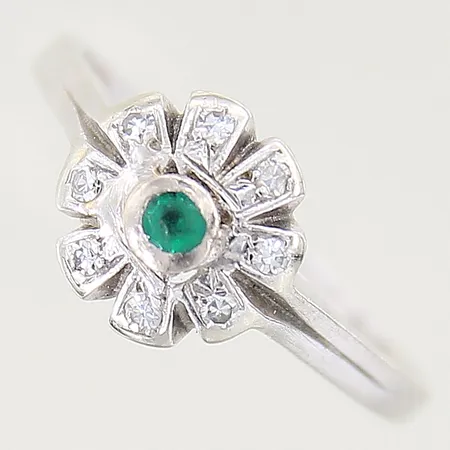 Ring med smaragd samt diamanter 8 x ca 0,01ct, stl 18, bredd 1-9mm, vitguld, spår av storleksändring, i behov av omrodiering, smaragd med slitage samt flertal nagg vid fasetter, 18K  Vikt: 3,4 g