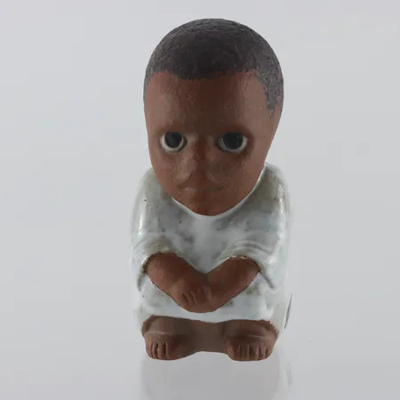 LISA LARSON. "Syd", figurin i stengods, ur serien "All världens barn", Gustavsberg,höjd ca 11 cm.