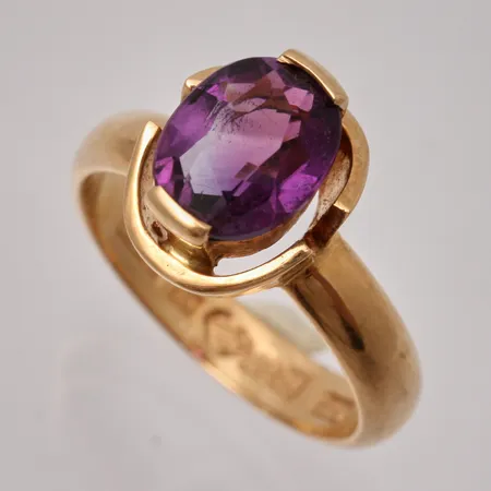 Ring i 18K guld, stl 16½, bredd 3,6-11,5mm, 1st lila sten, mått 7,2x8,8mm, personlig gravyr, bruttovikt 5,8g, ca nettovikt 5g.