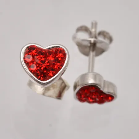  1par örhängen i silver, mått 7x6,1mm, små röda stenar i form av ett hjärta, 925/1000, ena snurrebussen 830/1000, vikt 1,28g.