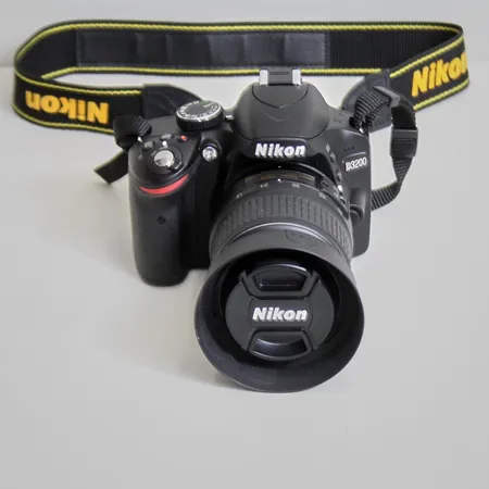 Digital systemkamera Nikon D3200, serie nr: 6990002, objektiv Nikon, DX 18-55mm 1:3,5-5.GG11, serie nr: 5789423, linsskydd, axelrem, ej laddare, minneskort. Väska medföljer. 