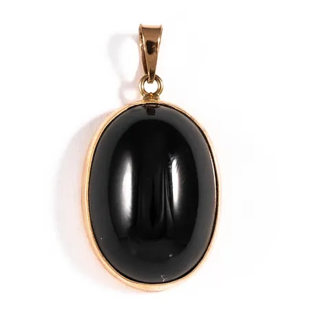 Hänge i 18K guld med en cabochonslipad svart sten c:a 17,5 x 12,5 mm. Det är 14 mm brett, 26 mm långt inkl. ögla och väger 3,1g. Stämplad DE (D. Ekström AB, Falköping), 18K och kattfot. Enstaka repa på sten, men annars blank och fin. 