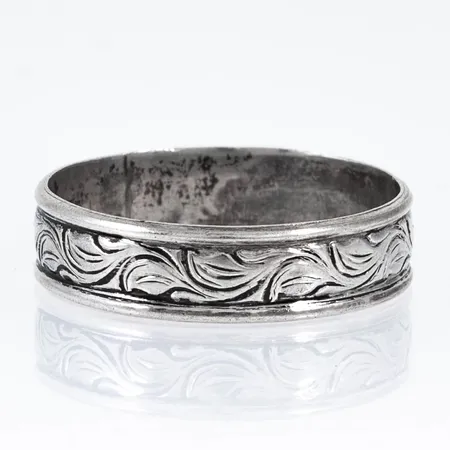 Ring i silver (830/1000) med mönstergravyr. Den är i storlek 21, är 6 mm bred och väger 2,8g. 