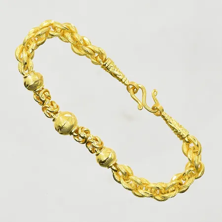 Armband med kulor, längd 14½ cm, bredd 5-7 mm, Thaiguld, 2 slung, 23K. Vikt: 7,6 g