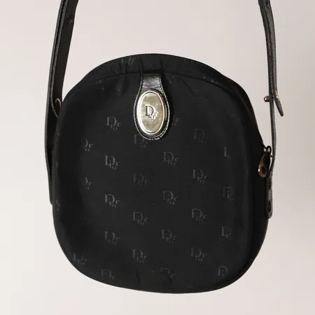 Väska Christian Dior, svart monogramcanvas, tyg, beslag i gulfärgad metall, mått ca   19 x 4 x 22cm, innerfoder i svart skinn, axelrem, ca 1980-tal, slitage på axelrem, invändigt slitage samt fläckar. 