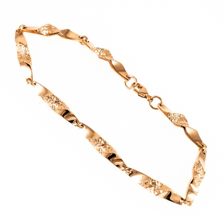 Armband i 18K guld: Ledade länkar med vildmarksmönster. Det är 19 cm långt, 2,5 - 4,5 mm brett och väger 8,2g. Fint skick. Karbinhake. 