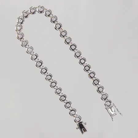 Tennisarmband med briljantslipade diamanter ca 32x 0,03ct, 3 indikerar på syntet, längd 19cm, bredd 5,7-8,3mm, en diamant sned i fattning, hack i länk, vitguld, 18K,  Vikt: 17,7 g