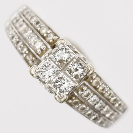 Ring med prinsesslipade diamanter 4 x ca 016ct, samt briljantslipade diamanter 36 x ca 0,01ct, stl: 17½, bredd: 3-7mm, 18K guld.  Vikt: 5,7 g