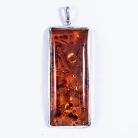 Stort rektangulärt hänge i silver (925/1000) med en bärnsten. Det är 4 cm brett, 12 cm långt inkl. ögla och väger 59,0g. Stämplad 925. 
