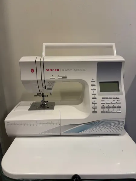 Symaskin Singer Quantum Stylist 9960 med tillbehörslåda.  Det finns yttre synliga skador samt att kontakten i symaskinen för pedalen är lös. Om det finns några som påverkar funktionerna så vet vi inte det.  Ej funktionsgaranti skickas ej, hämtas på plats. Specialfrakt, kontakta pantbankskontoret för mer information.