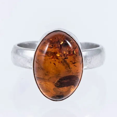 Ring i silver (925/1000) med en bärnsten c:a 14,5 x 10,5 mm. Den är i storlek 17½, är 4 - 15 mm bred och väger 5,0g. Stämplad 925. 