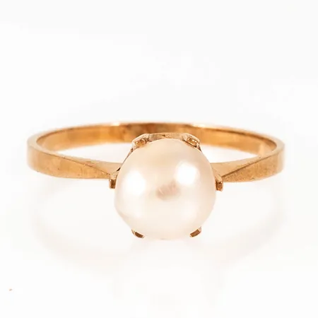 Ring i 18K guld med odlad pärla Ø 7 mm. Den är i storlek 17½, är 1,5 - 7 mm bred och väger 2,1g. Något oval skena, ojämn pärla. 