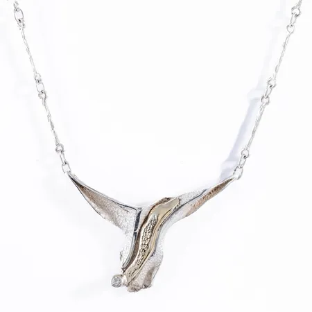 Collier i silver (925/1000): Integrerat hänge med guldfärgad dekor och vit sten (cz). Det är 43 cm långt och väger 8,1g. Hängets mått 38,5 mm brett, 27 mm långt. Karbinhake. Stämplad JOA, 925S. 