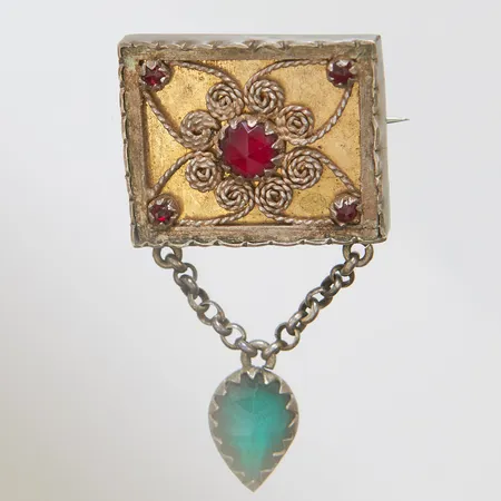 Brosch i allmogestil med filigranarbete samt röda och gröna glasstenar, 47x25,7mm, Petrus Dahlén, Stockholm, 1897, silver Vikt: 8,2 g