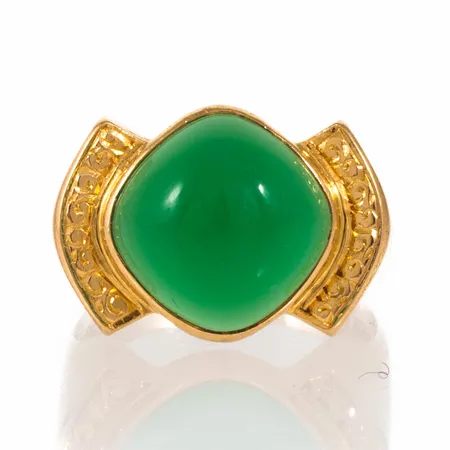 Ring i 18K guld med en cabochonslipad äppelgrön sten 11 x 11 mm (sannolikt agat). Den är i storlek 17, är 3,5 - 13 mm bred och väger 5,7g. Stämplad D9 (1954), Stigbert, HE (Heribert Engelbert AB, Stockholm), 18K och kattfot.