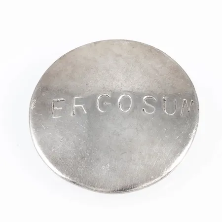 Hänge i silver (925/1000) med instansad text ERGOSUM som betyder "jag tänker, alltså finns jag". Det är Ø 30 mm och väger 11,9g. Stämplad 925. 