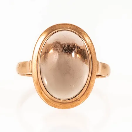 Ring i 14K guld med en cabochonslipad ljusbrun sten 14 x 10 mm (sannolikt rökkvarts). Den är i storlek 17¼, är 2 - 17 mm bred och väger 3,5g. Finska stämplar. Repig sten, gravyr.