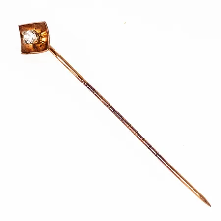 Nål i 18K guld med vit sten. Den är 52 mm lång, 8 mm bred och väger 0,8g. Missfärgning.