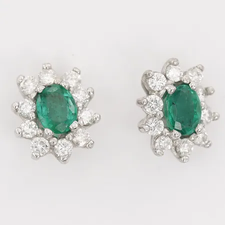 Ett par örhängen carmosé, med ovalslipade smaragder 5 x 4mm, samt briljantslipade diamanter 20 x ca 0,02ct, längd: 9mm, bredd: 8mm, skruvsystem, snurrebussar saknas, 18K vitguld.  Vikt: 2,1 g