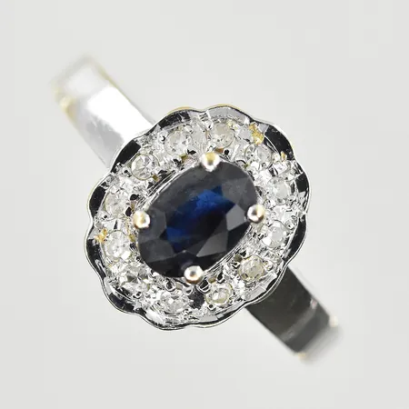 Ring med diamanter 12x0,01ct och mörkblå safir 6x4 mm, stl 16¾, bredd 2-12 mm, vitguld, 18K. Vikt: 2,9 g