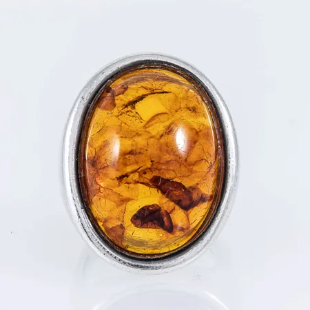 Ring i silver (925/1000) med en bärnsten c:a 25 x 18 mm. Den är i storlek 18, är 5,5 - 59,5 mm bred och väger 14,7g. Stämplad W.&S.S, 925S, S och svensk importstämpel. Bruksslitage.