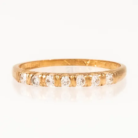 Defekt/graverad ring i 18K guld med 7 x 0,03ct briljantslipade diamanter. Vikt: 1,5g.