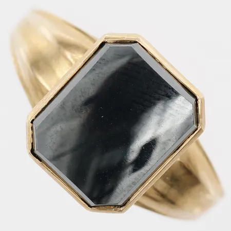 Klackring med onyx, stl: 19¾, bredd: 2 - 12mm, gravyr, 18K guld. Vikt: 3,8 g