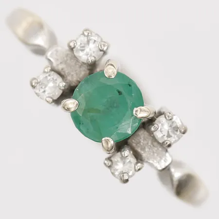 Ring med smaragd  samt diamanter 4 x ca 0,03ct, stl: 15½, bredd: 1 - 6mm, smaragd med mindre nagg, 18K vitguld.  Vikt: 2,7 g