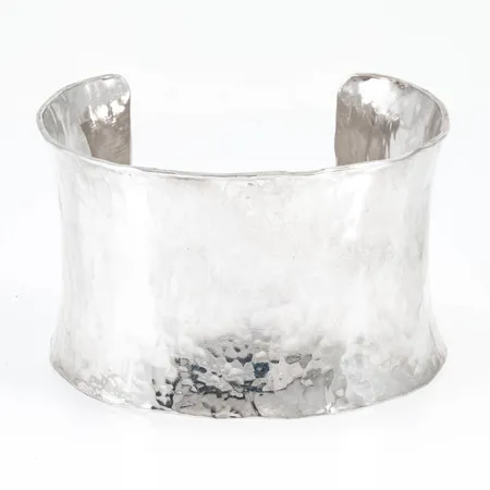 Stelt armband i hamrat silver. Bredd 44 mm. Inre omkrets 14 cm + 3,5 cm öppning. 92,4g 925/1000.