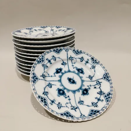 Tolv assietter Royal Copenhagen Musselmalet helblond, genombruten spetskant, nr:1087, Ø17, porslin Skickas med postpaket.