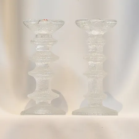 Ett par ljusstakar ur serien "Festivo", formgiven av Timo Sarpaneva för Iittala, höjd: 18,5cm etikettmärkta, klarglas  Skickas med postpaket.