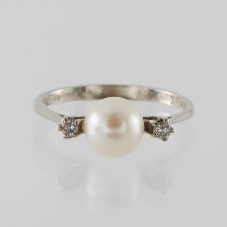 Ring 18k vitguld med pärla och 2 st diamanter på totalt 0.08 ct enligt inskription,Italienska stämplar,storlek ca 18 mm,bredd 2.2-7.7 mm. Vikt: 2,6 g