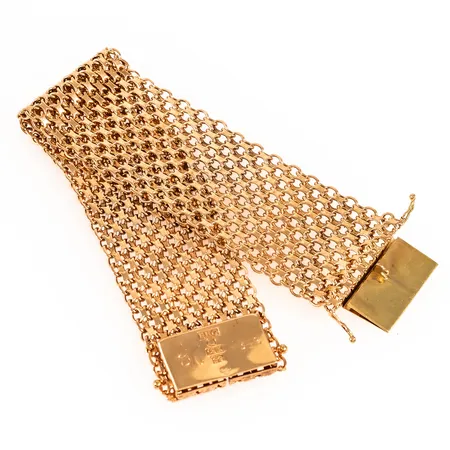 Brett armband x-länk 18 cm långt 28,6 mm brett 47,2g 18K. Modell 11 X utan stav. Kistlås med monogramgravyr under. Tillverkat 1968 av Bröderna Hedens Guldatelje i Stockholm.