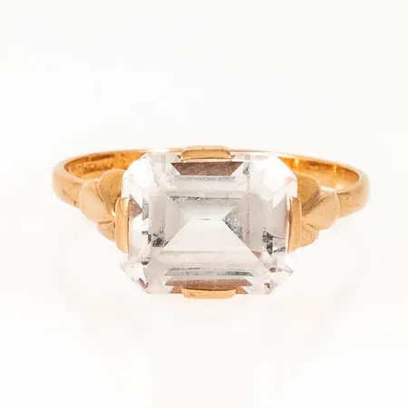 Ring vit sten troligen syntetisk spinell stl:19½, naggade fasetter, lös i fattning, något skev skena 18K 3,7g.