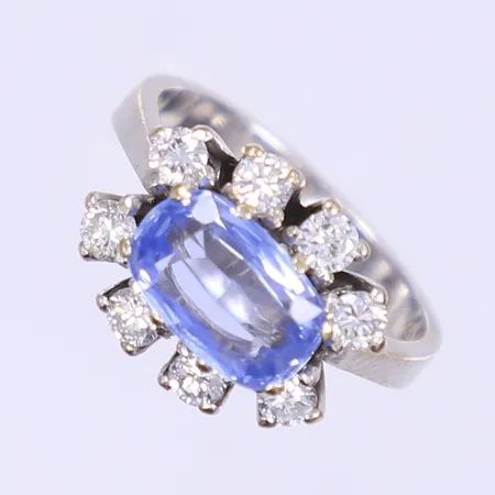 Carmoséring med diamanter 8x ca 0,08ct samt ljusblå safir ca 1,25ct, stl 16¾, bredd 3-12mm, importstämplad, vitguld 18K Vikt: 6,3 g