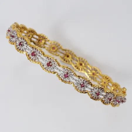 Armring med dekor samt rubiner 22 x ca 0,03ct totalt 0,66ctv, öppningsbar, Ø67mm, bredd 8,3mm, tvåfärgat 14K.  Vikt: 23,9 g