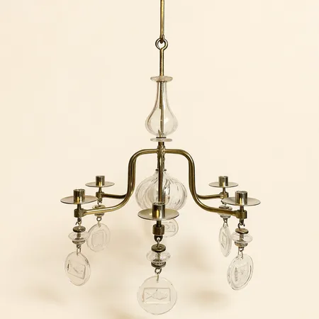 Ljuskrona Erik Höglund glas / smide gulmetall Ø46cm höjd exklusive extralänkar 61cm, 4 extralänkar för upphängning längd per styck 16,5cm, färgbortfall vid ljusen, spricka i ett glas Skickas med postpaket.