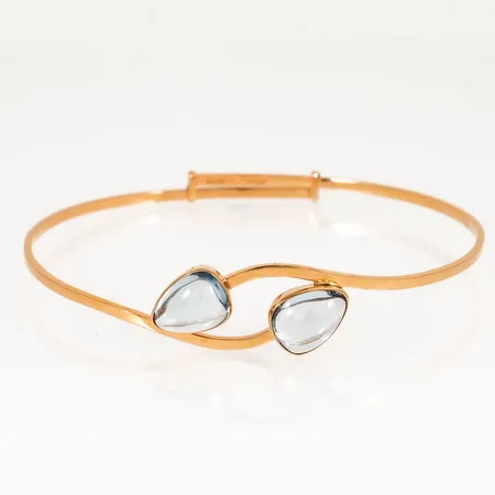 Stelt armband med två ljusblå stenar, innermått 18,5cm (justerbar, ger efter ca 2cm +), bredd 1,7-12mm 18K 8,6g. 