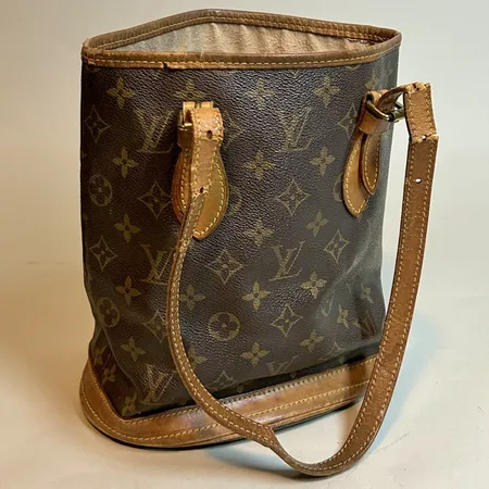 Väska Louis Vuitton Petite Bucket monogram, canvas, läder, guldfärgade beslag, öppen upptill, dubbla justerbara axelremmar, ett innerfack med dragkedja, ett innerfack öppet, VI 0978, gjord i Frankrike vecka 09 år 1978, nött kant upptill, nötta axelremmen av på 4 ställen, innerfodret vittrat Vikt: 0 g Skickas med paket.