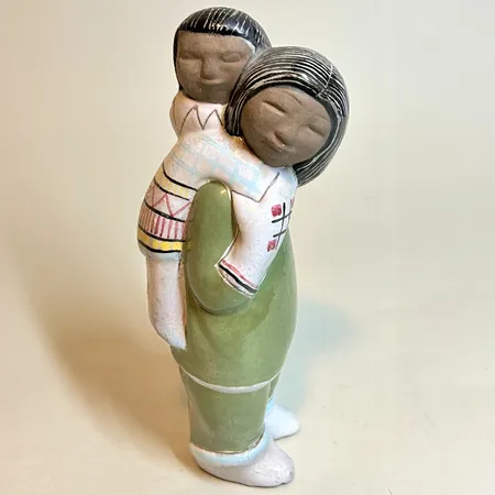 Figurin Upsala-Ekeby Inuitkvinna med barn Mari Simmulson längd 22cm bredd 7cm, stämplad UE SWEDEN 4295, stengods, nagg vid fötterna Skickas med postpaket.