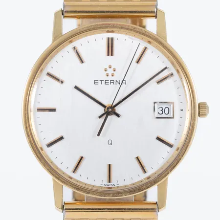 Herrur Eterna Q 18K quartz 33,5mm, datum, plexiglas, länk i doublé 18,5/19cm, viklås, gravyr, repigt glas.  Vikt: 0 g