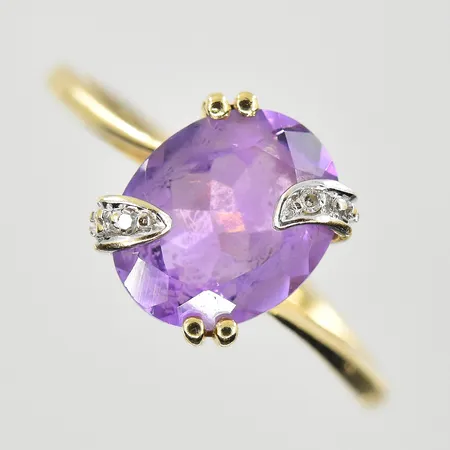 Ring med 2 diamanter och lila sten stl:17¼, bredd 1-10 mm, skev skena, 18K. Vikt: 2,6 g