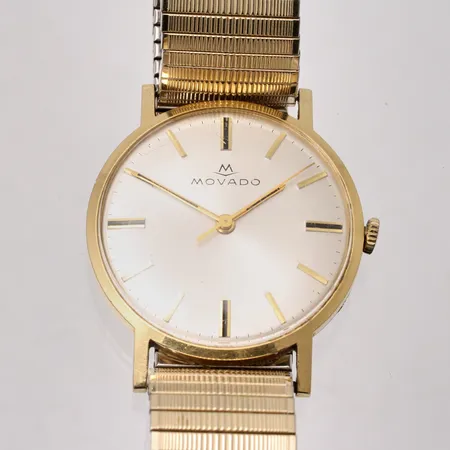 Herrur Movado 18K guld, manuell Ø34cm, serie:nr 280214029, ref:nr 1350, flexband i gulmetall, krokig krona, repor på glas, gravyr på boett, inga tillbehör.