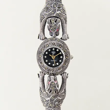 Damur med dekor samt motiv av tigrar, prydd med markasiter samt syntetiska rubiner stål quartz Ø22mm, integrerad länk i silver 925/1000, index med vita stenar, längd ca 19,3cm, i behov av batteribyte, bruttovikt: 32,6g